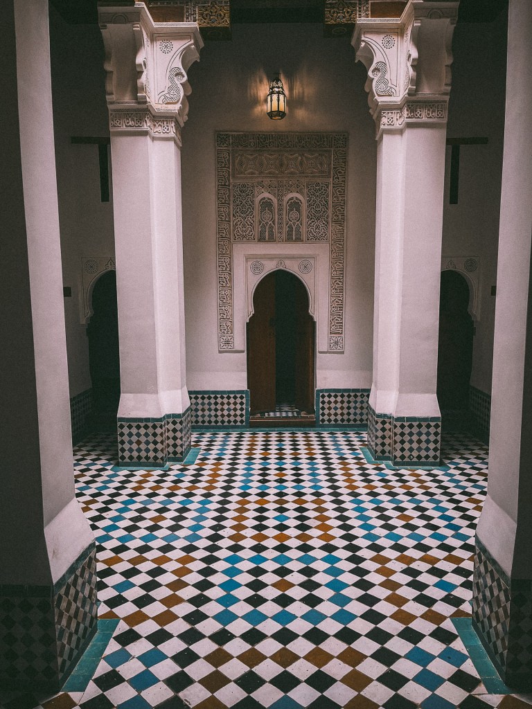 Interior view of a Moroccan architectural space featuring intricate tile work and decorative columns.
