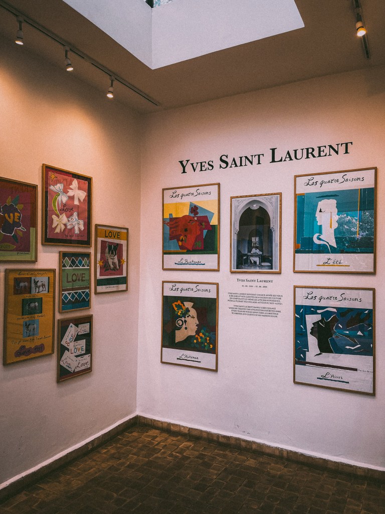 Interior view of the Yves Saint Laurent Museum showcasing colorful artwork related to the four seasons, with a focus on love, creativity, and fashion.